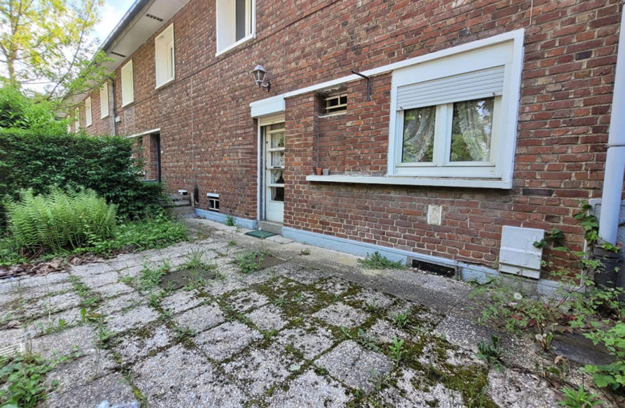 Maison de construction années 60 avec 3 chambres, jardin, parking devant la maison.