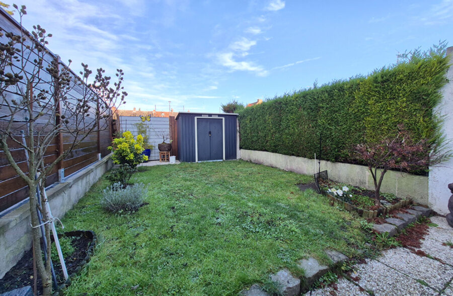 Maison avec 4 chambres, jardin et garage, située dans une rue calme.